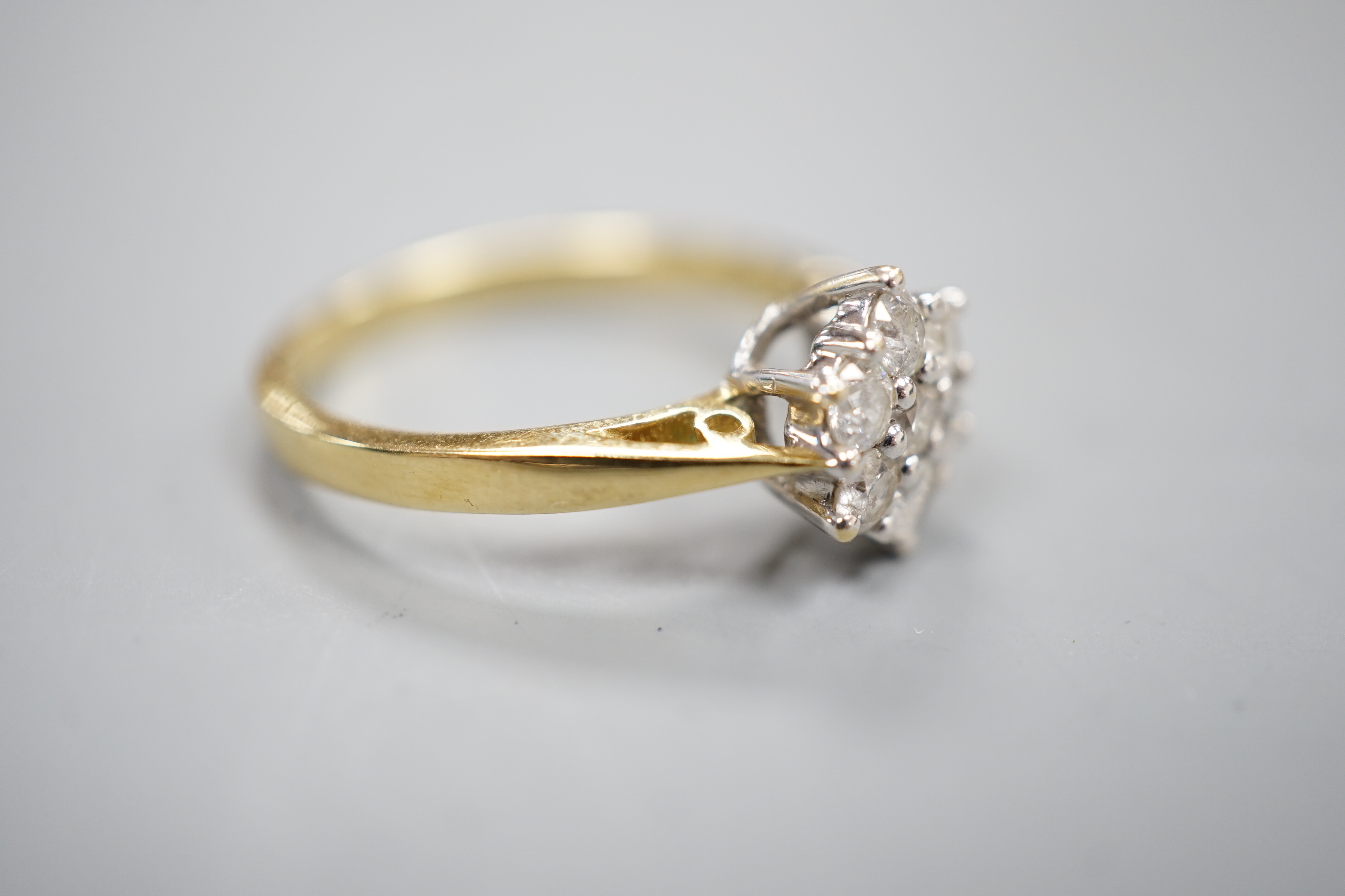 A modern 18ct gold and seven stone diamond set cluster ring, size O, gross 3.4 grams.